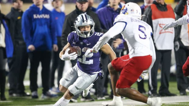 Nov 26, 2022; Manhattan, Kansas, USA; Kansas State Wildcats running back Deuce Vaughn (22) carries the ball against Kansas Jayhawks safety O.J. Burroughs (5) during the fourth quarter at Bill Snyder Family Football Stadium. Mandatory Credit: Scott Sewell-USA TODAY Sports